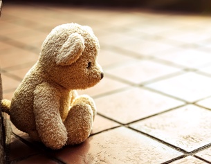 Kleiner Teddybär bei gefliesten Stufen