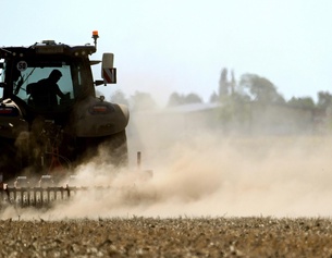 Traktor auf dem Feld: Staub und trockene Erde