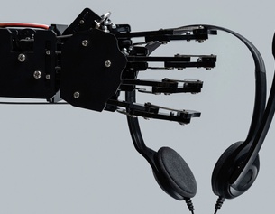 Eine Roboterhand hält ein Headset.