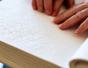 "Herr der Ringe" in Braille-Schrift: lesende Finger