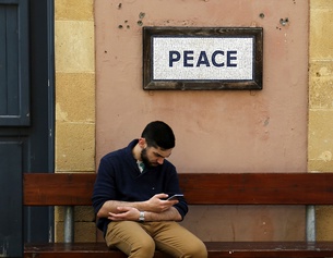 ASSOCIATED PRESS Ein Mann vor einem Schild mit der Aufschrift "Peace"