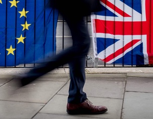Passant vor EU- und UK-Fahnen