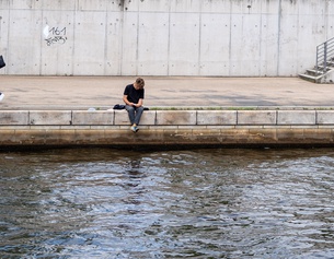 Lesender Mensch an der Spree in Berlin
