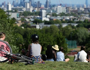 AFP/ISABEL INFANTES Menschen sitzen in einem Park und schauen in die Ferne.