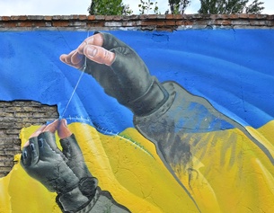 Graffiti zeigt die ukrainische Fahne, die zusammengeflickt wird
