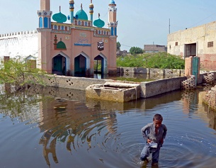 Ein junge wartet durch das Hochwasser in Pakistan.