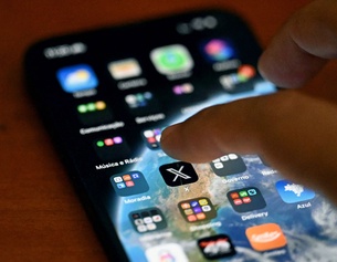 Männerhand über einem Smartphone-Display: Social-Media-Plattform X