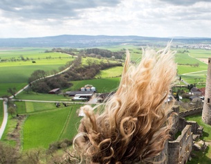 APA/DPA/FRANK RUMPENHORST Haare wehen im Wind, dahinter Burgruine