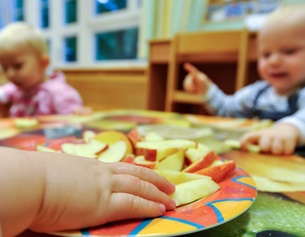 Kleinkinderhand mit Apfelspalten