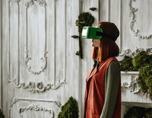 Frau mit VR-Brille in einem historischen Raum mit Moosbewuchs