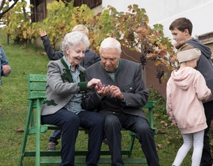ULLA SLADE Zwei ältere Menschen mit Kindern am Hof