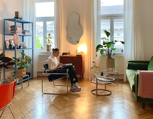 Eine Frau liest sitzend in ihrer Wohnung - "wie wien wohnt"