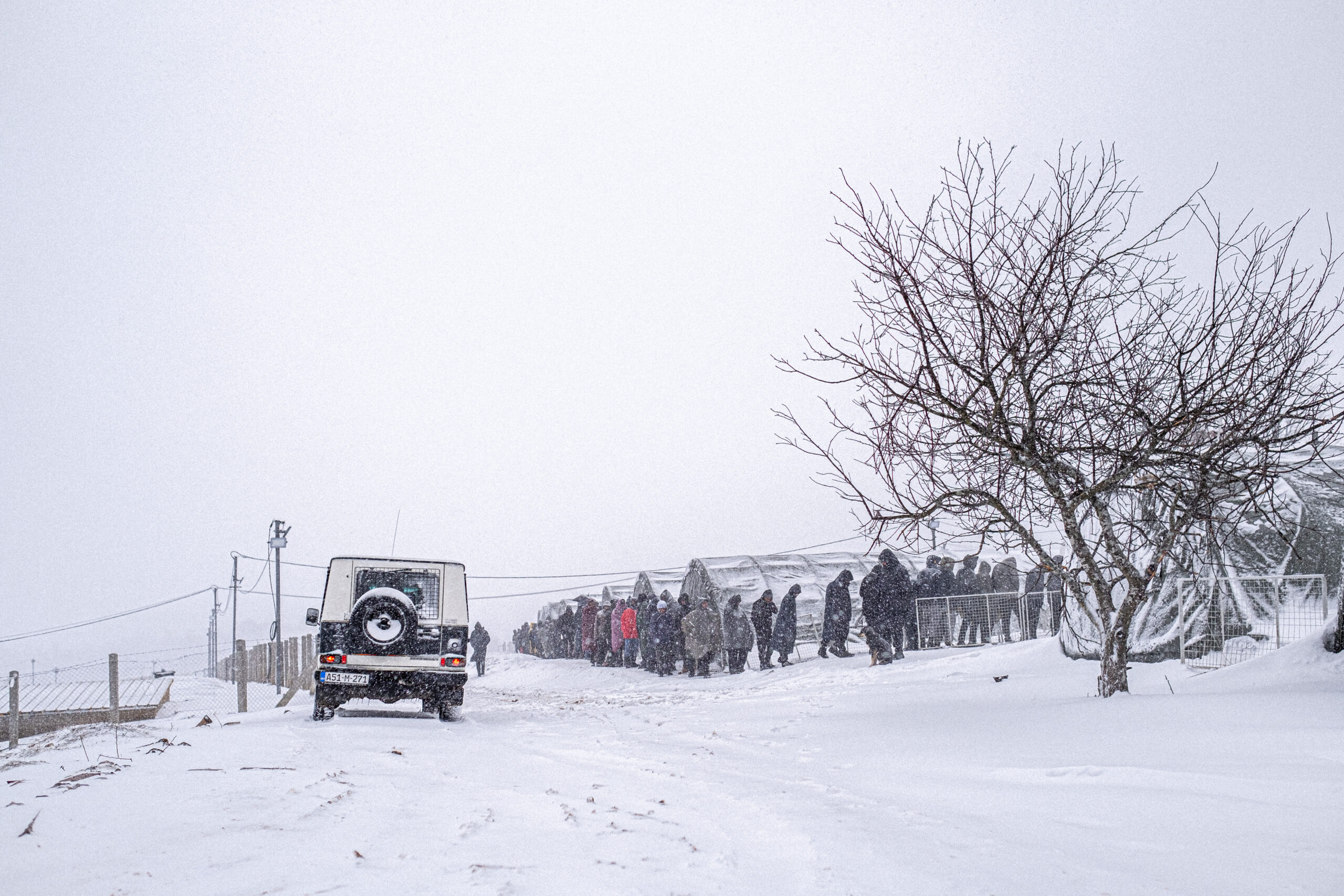 The picture shows refugees queue during heavy snowfall waiting for a food distribution organised by the Austrian NGO SOS Balkanroute and the local Red Cross in January 2021 at the Refugee Camp Lipa in Bosnia Herzegowina.